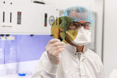 A scientist at SK Siltron CSS holding a silicon carbide wafer produced at the company's Auburn Hills' facility. // Courtesy of SK Siltron