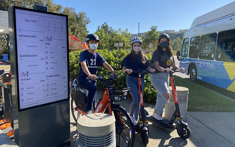 UC San Diego students next to a Spin Hub with a TransLoc-powered information board updating bus information. // Courtesy of TransLoc