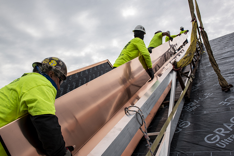 A team from CASS Sheetmetal in Detroit works on a roofing project at Water Works Park in along the Detroit River.